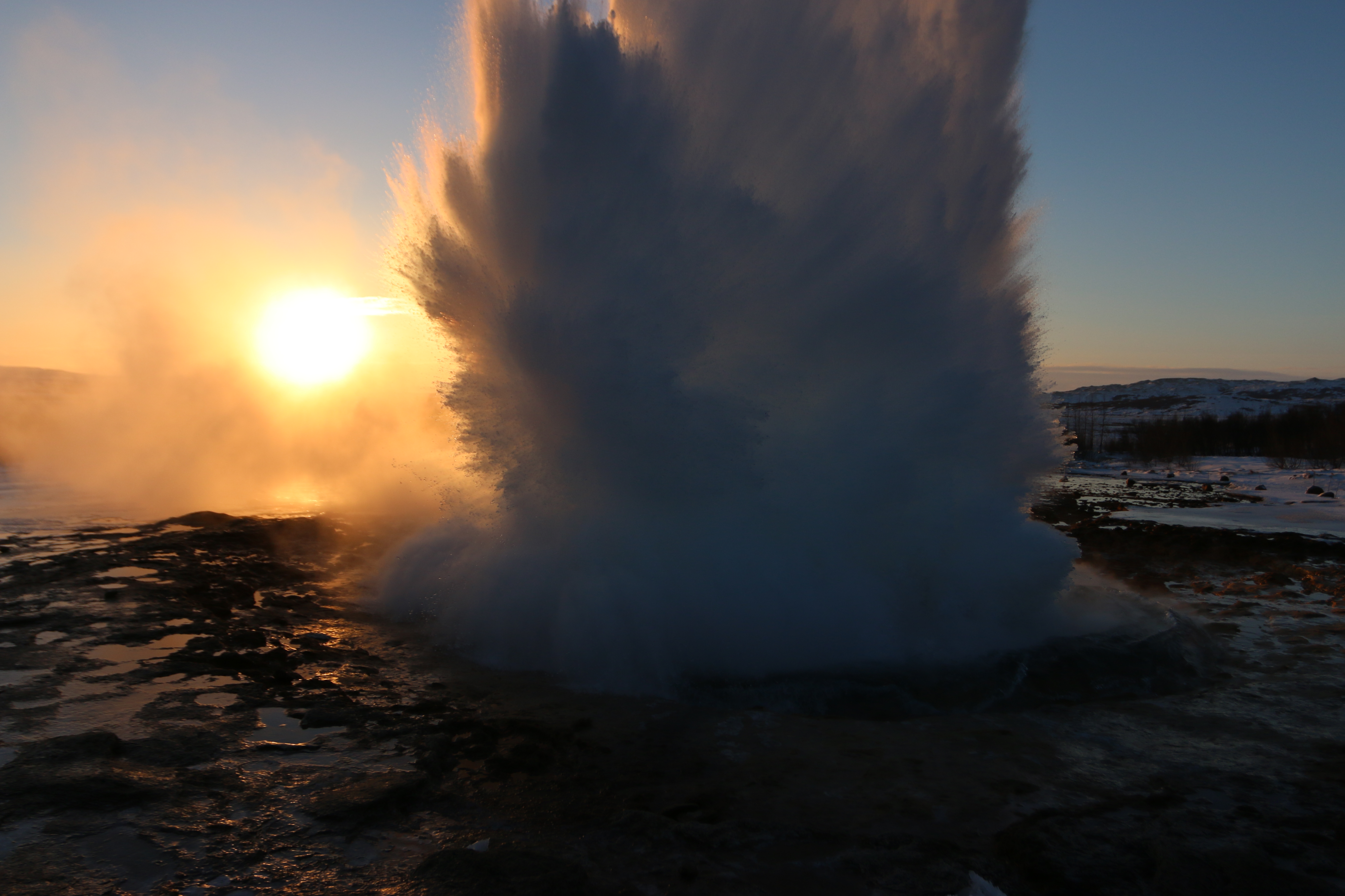 Geysir exploding in front of Iceland's perfect, if ephemeral, golden winter sun.